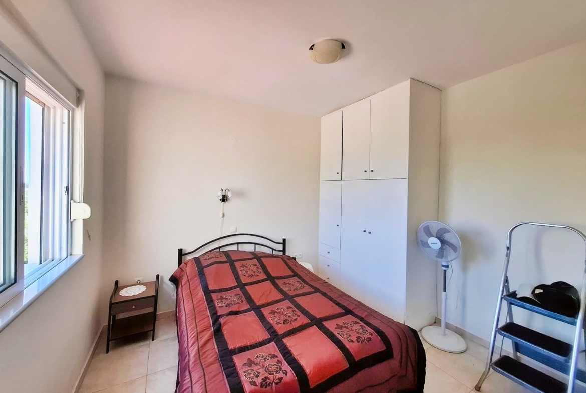 Second floor one-bedroom apartment with a sea view & shared pool in Tavronitis